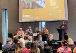 Bildet viser Hanna Charlotta Dencik Petersson som presenterer AHOs søknad foran et publikum