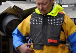 Fisker på en båt i Lofoten har på seg en vest designet av AHO-student Johan Møller